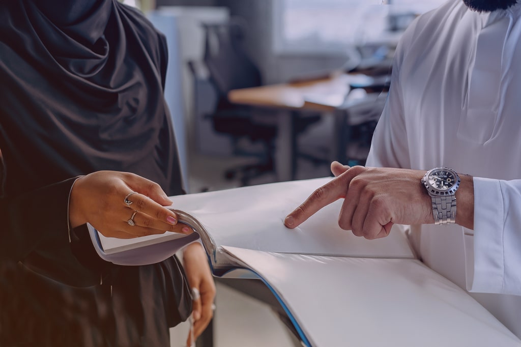 Image of employees holding a document and going through it.